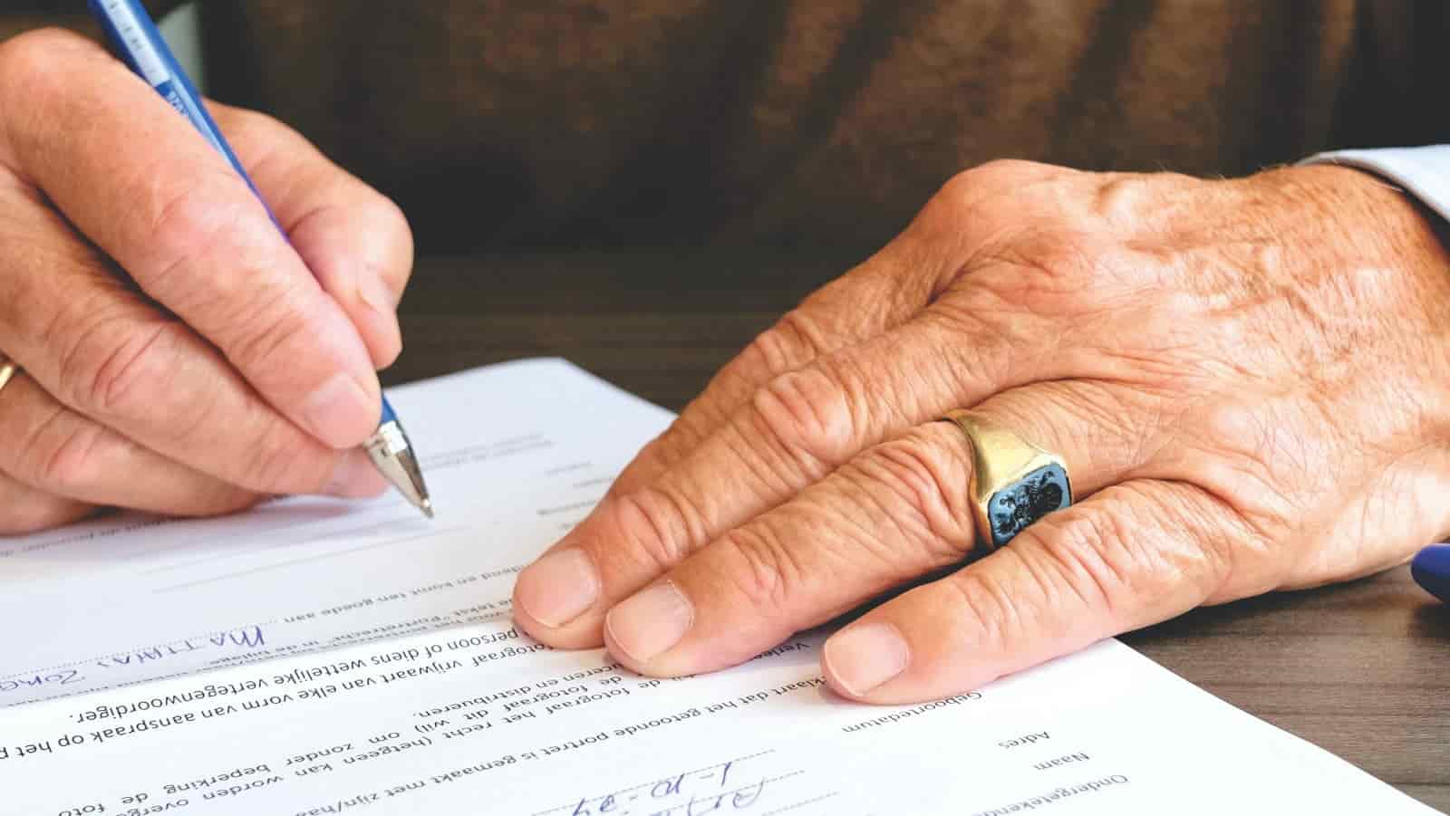 Mains remplissant un formulaire administratif au stylo